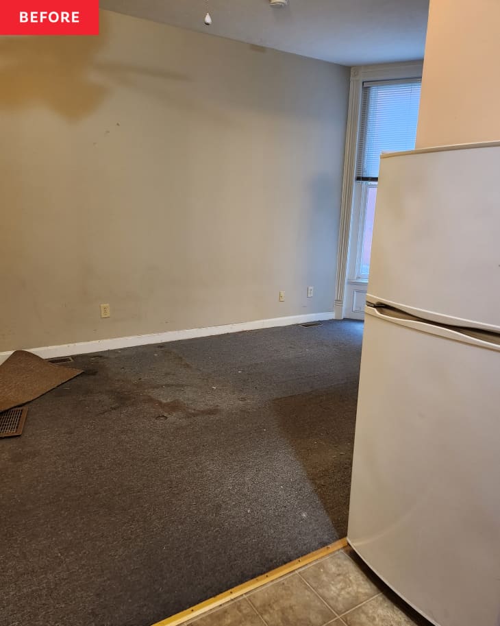 studio space before renovation. Large empty room with floor peeling up, gray walls