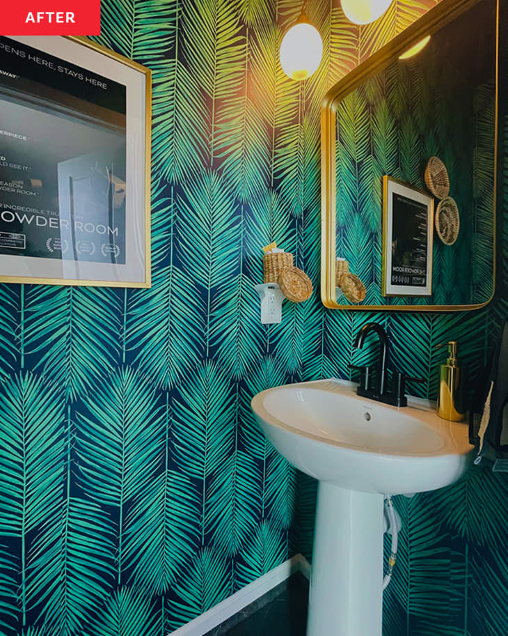 Bathroom after renovation with palm leaf motif wallpaper and white pedestal sink.