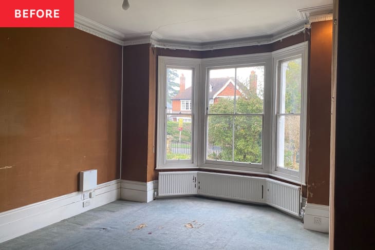 Room before being converted into home office: Large bay windows, empty room with brown walls, gray floor