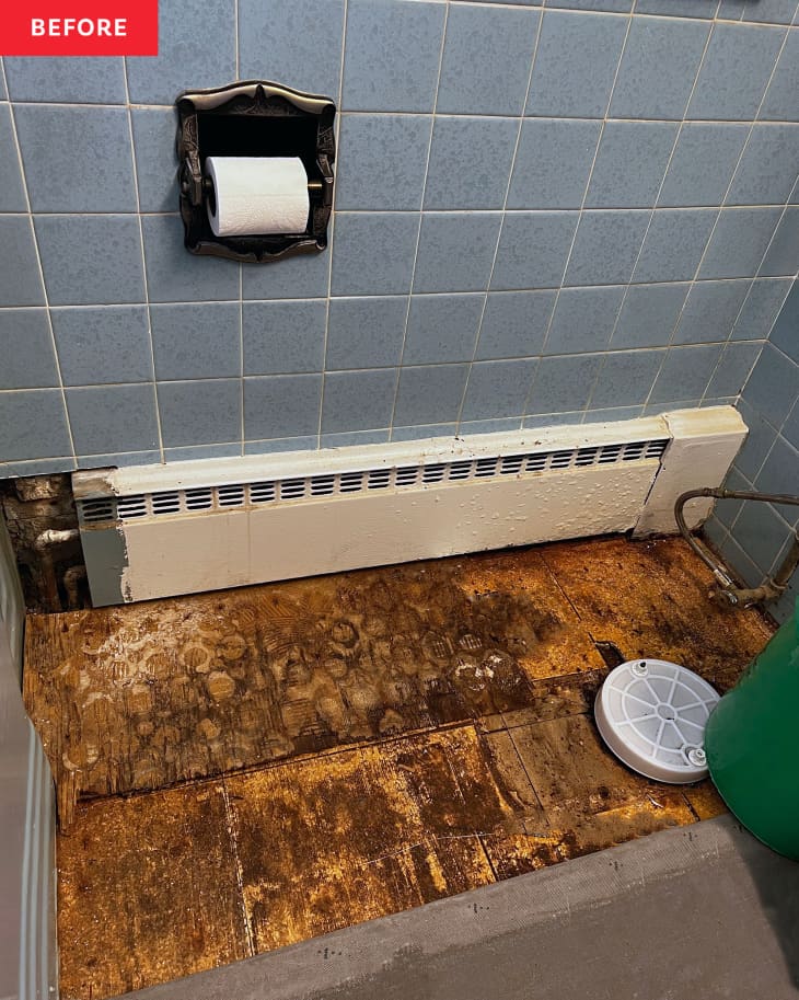 Bathroom tiles pulled from floor with floorboards exposed.