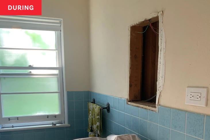 Bathroom with medicine cabinet removed during renovation.