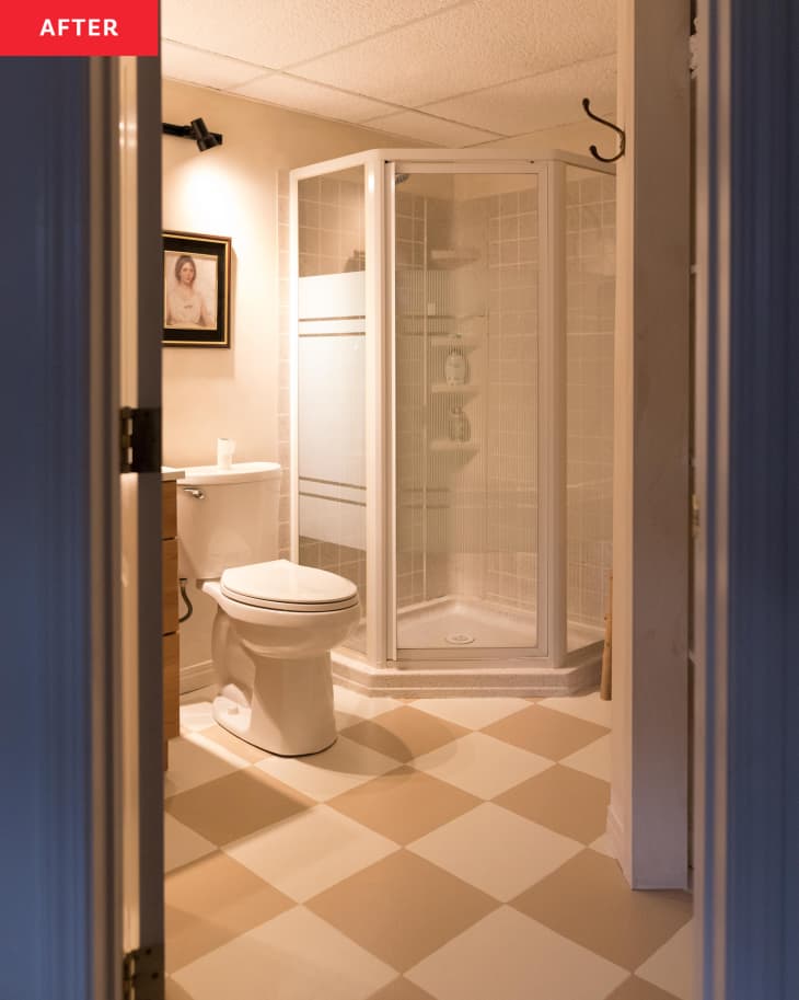 Bathroom with beige and white checkerboard flooring and shower with glass door after renovation.