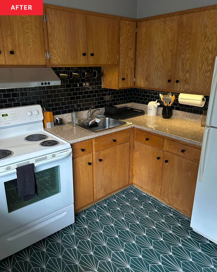 Kitchen with green tiles and black backsplash behind stove after renovation.