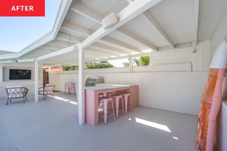 Pink painted bar with bar stools around in backyard.