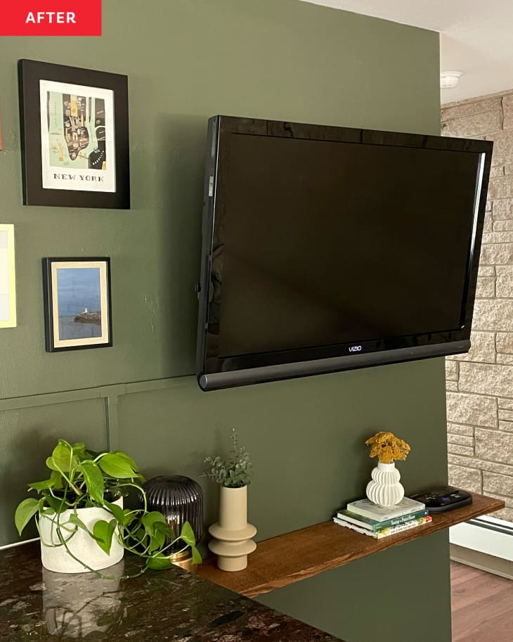 TV wall after diy makeover: Wall painted dark green with white trim, shelf added with plants. Art on walls around TV