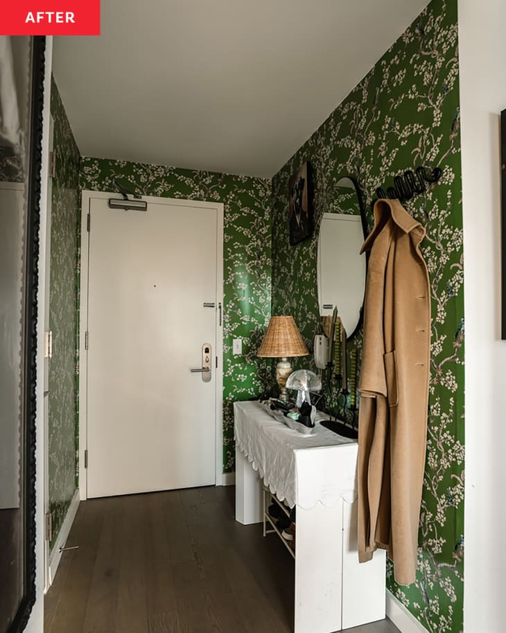 Green floral wall paper and white side table in apartment entryway