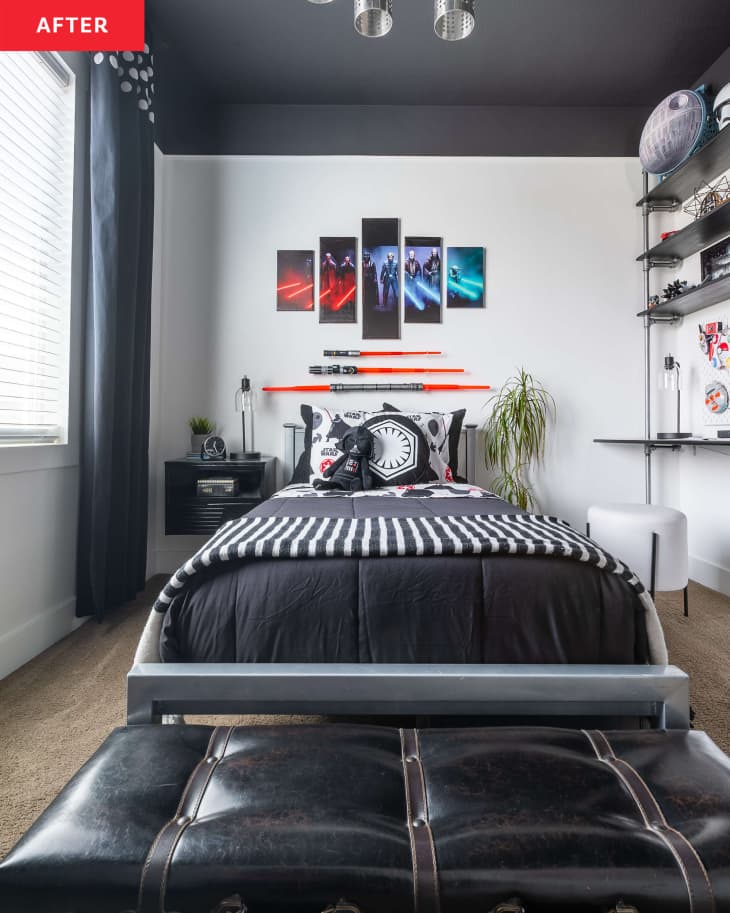 Ceiling painted black in a star Wars themed kid's bedroom with light sabers mounted above neatly made bed with black and white bedding.