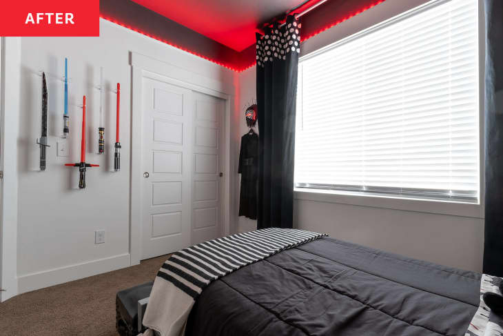 Red LED lights strung around ceiling in Star Wars themed kid's room with light sabers hung on wall by closet door and costume hung in corner near window.