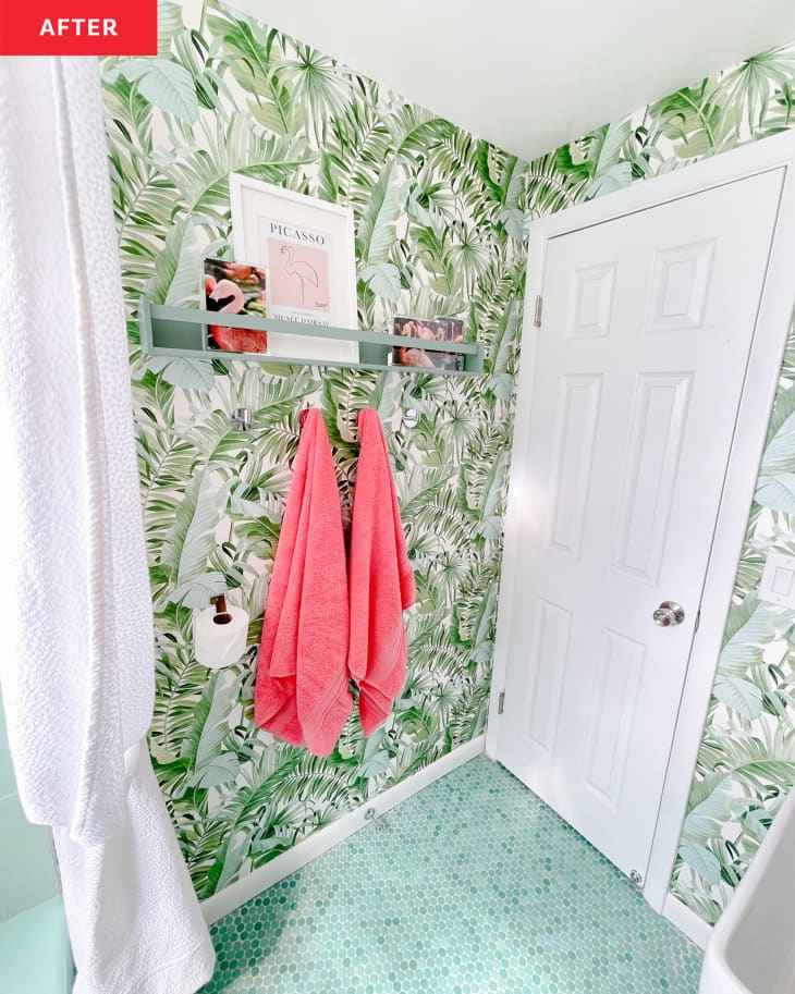 Newly renovated bathroom with green botanical wallpaper and bright pink towels hung. Green open shelves display props and artwork.