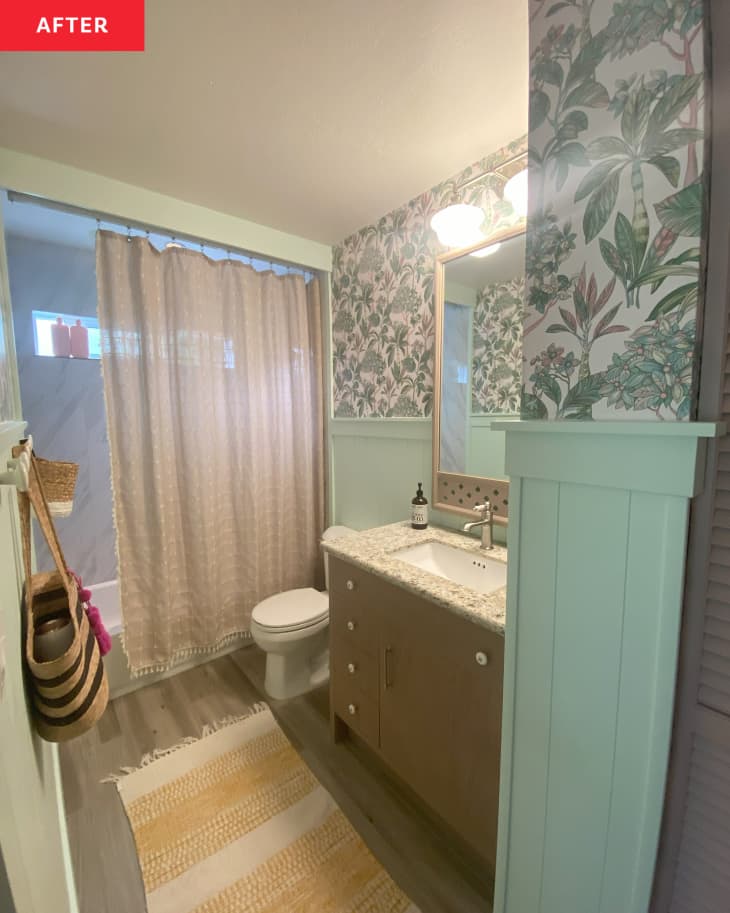 Newly renovated bathroom with floral wallpaper and green wainscoting.