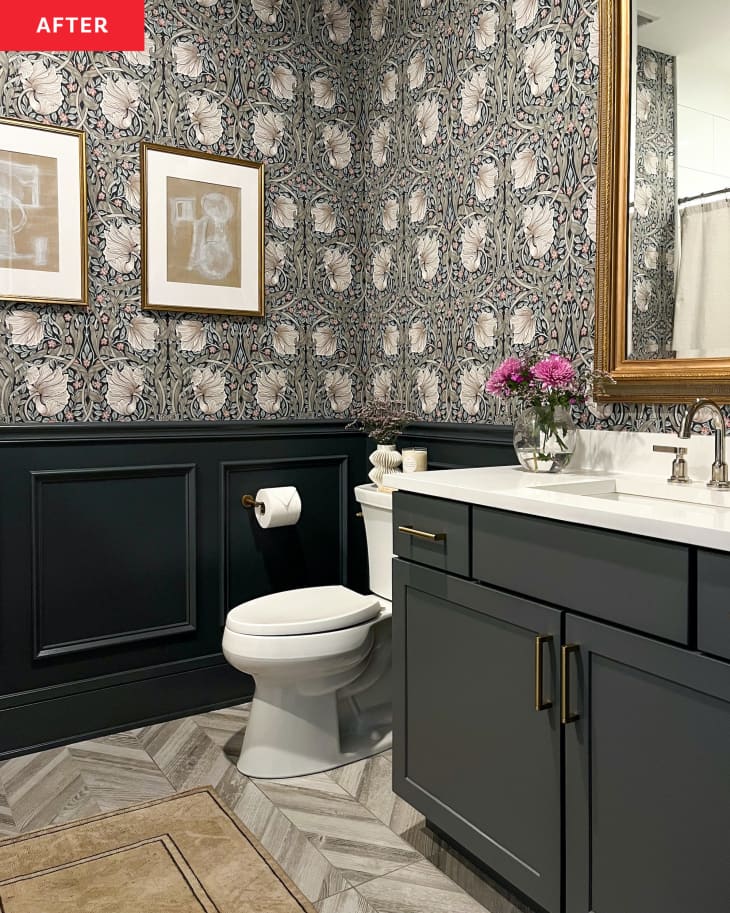 Dark vanity with light countertops in newly renovated bathroom with dark painted wainscoting and floral wallpaper.