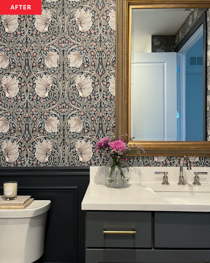 Small floral arrangement on light colored vanity in newly renovated bathroom with floral wallpaper.