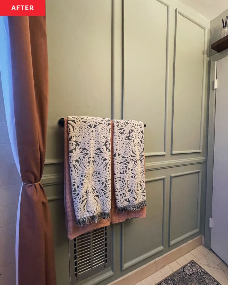 Floral pattern bath towels hung on wall in in newly renovated bathroom.