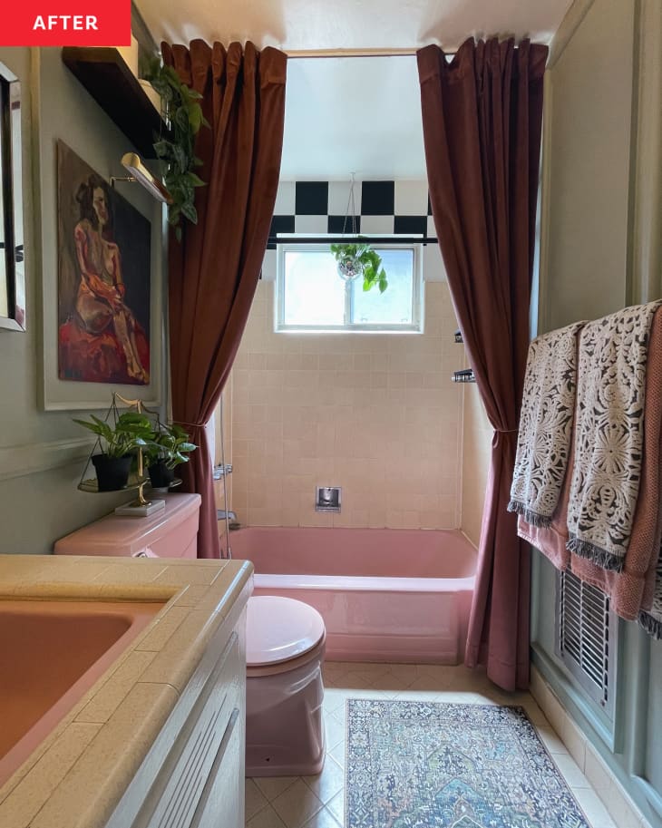 Colorful bathroom after renovation with rust colored shower curtains and vintage pink bathtub.