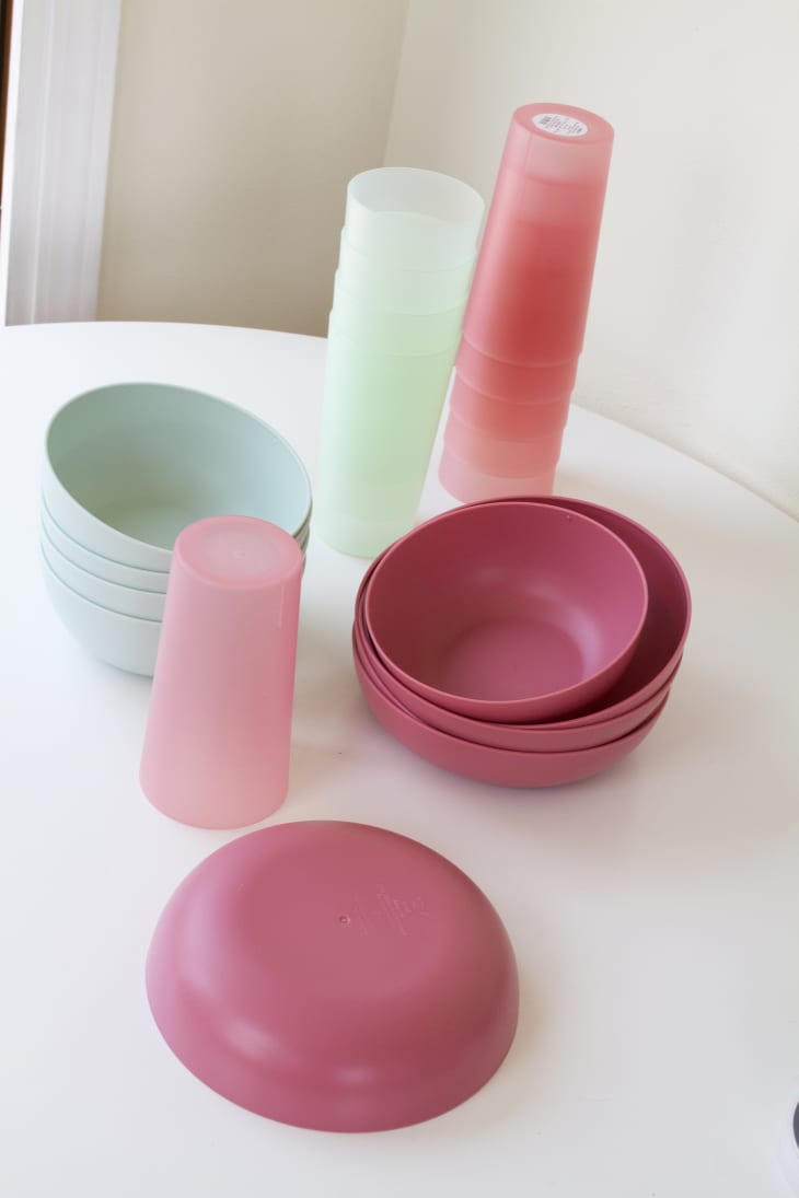 Stacks of plastic bowls and cups in light green and light pink