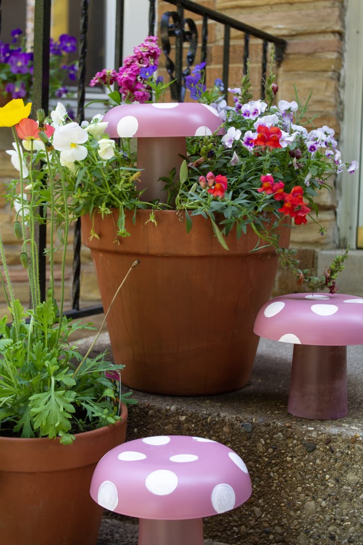 DIY mushroom lawn ornaments displayed on porch stairs with potted plants