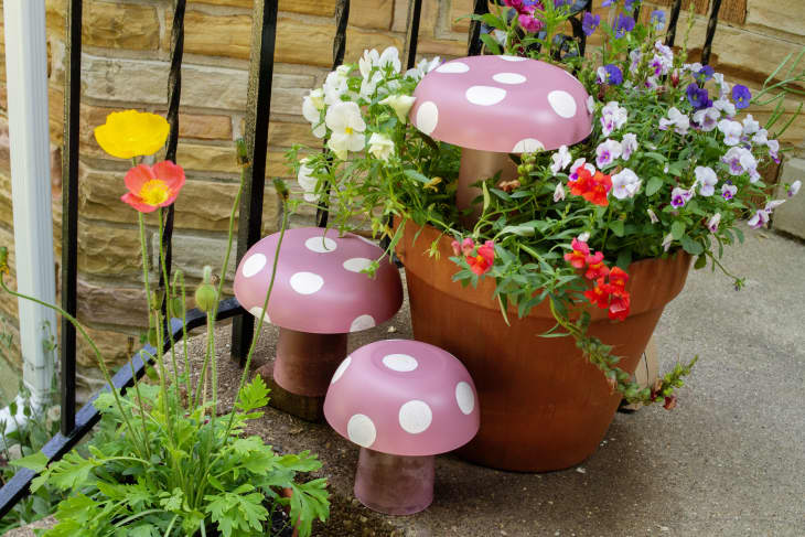 DIY mushroom lawn ornaments displayed on porch stairs with potted plants