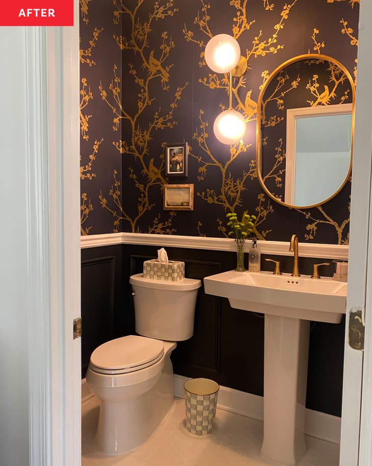 不wly renovated powder room with dark painted wainscoting and navy blue and gold floral wall paper and gold accents throughout.