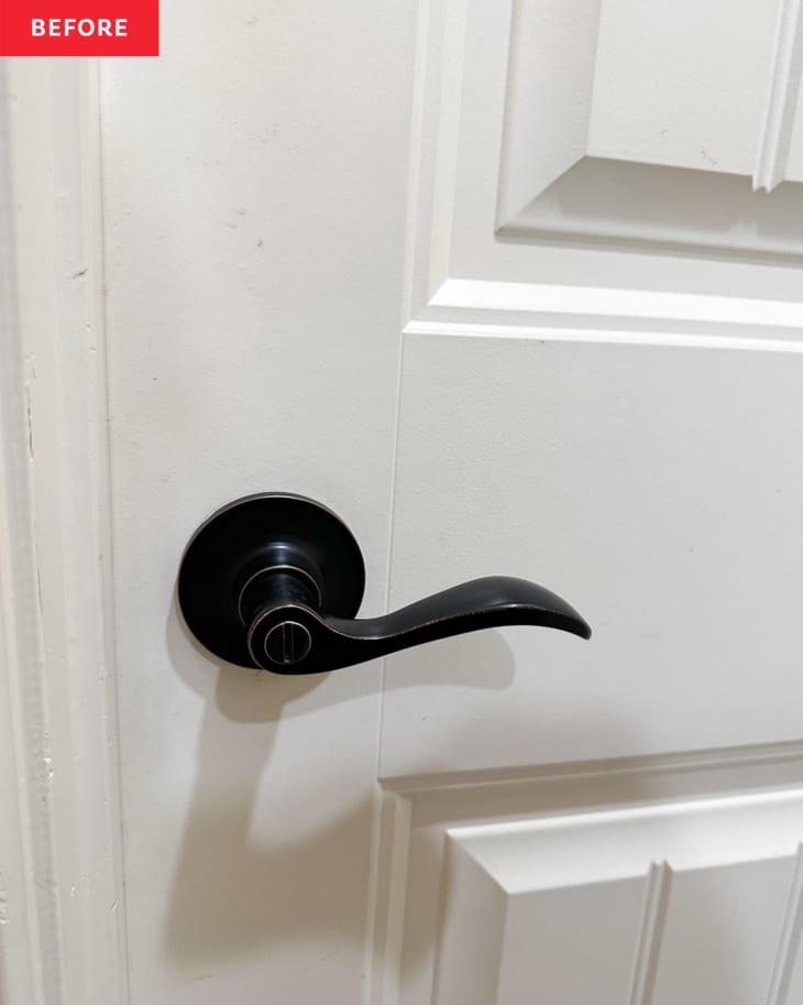 Black door handle on bathroom before renovation.