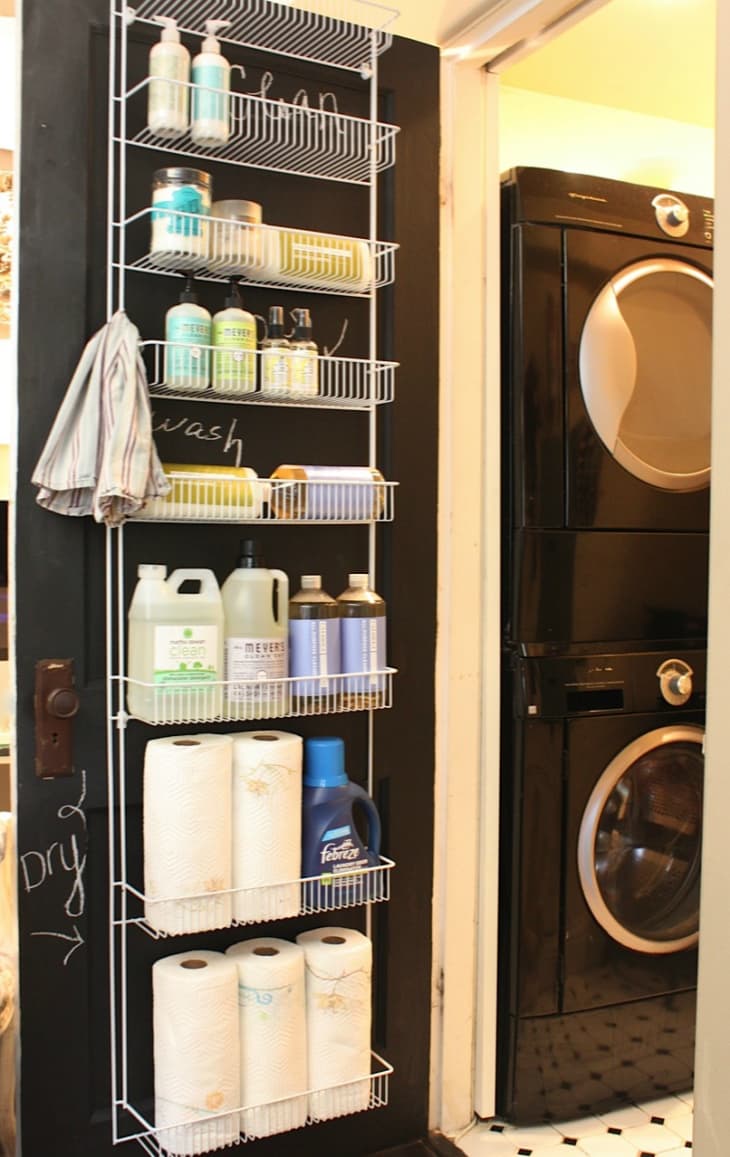 a wire shelf rack hanging over a chalkboard-painted door filled with cleaning and laundry products
