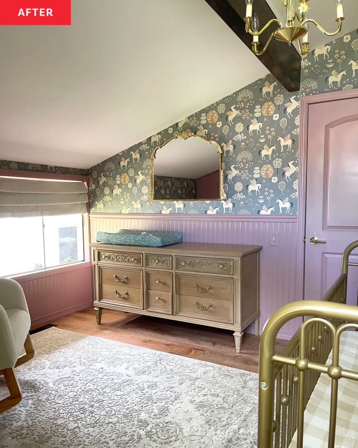 Nursery after renovation: one rose-colored wall and other green pegasus print wallpapered wall, chandelier, pink cabinets, crib with canopy