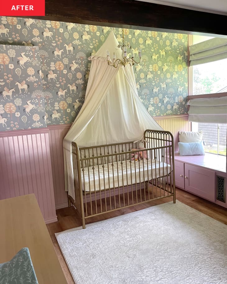 Nursery after renovation: one rose-colored wall and other green pegasus print wallpapered wall, chandelier, pink cabinets, crib with canopy