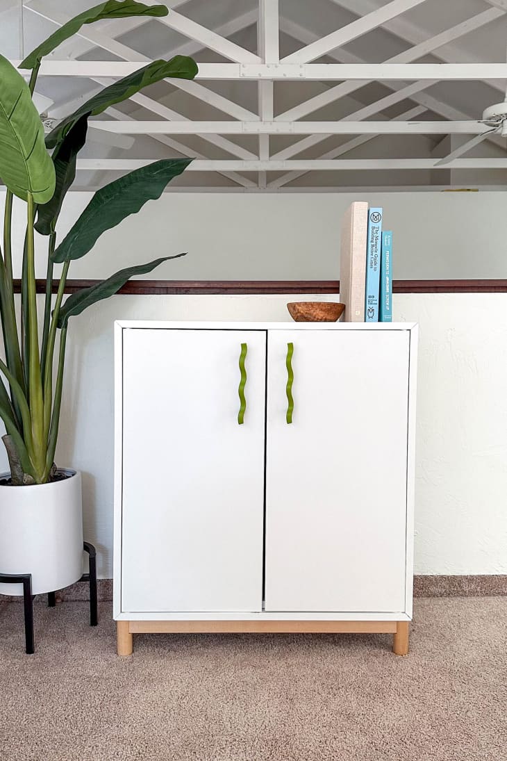 A white cabinet with silver handles