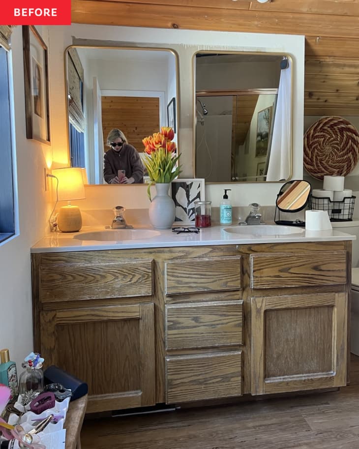 A bathroom with a white and wood countertop and large  mirrors.