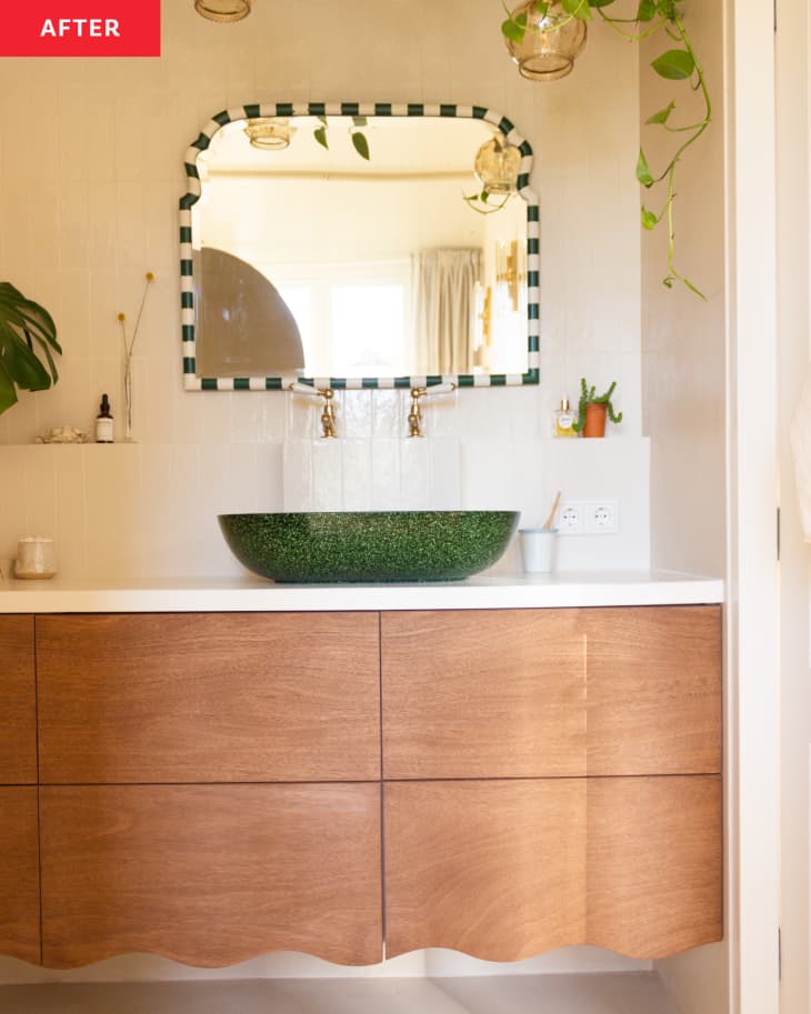 Plants hang from the ceiling above a sink area in a bathroom.