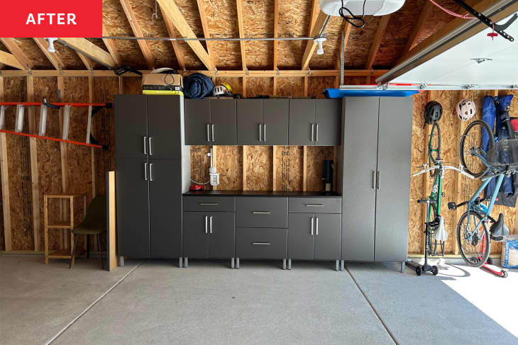 An organized two-car garage with a work space and cabinets.