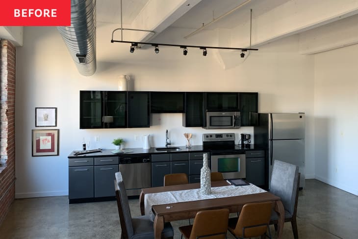 A white kitchen with black glass overhead cabinets and grey base cabinets.