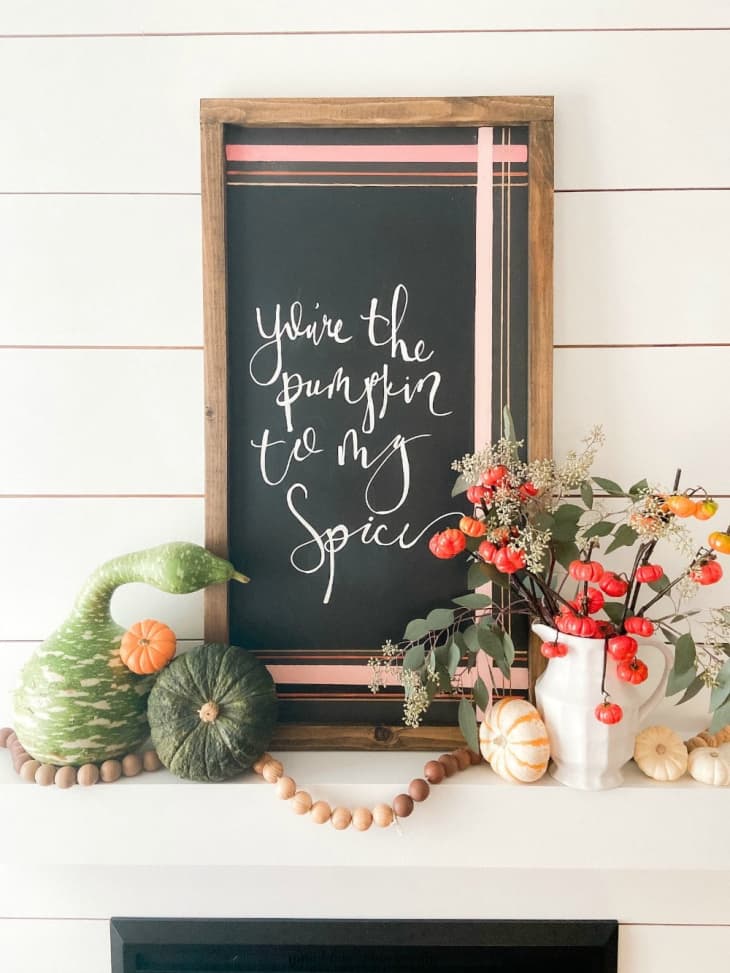 Mantel with chalkboard resting on top, with pink plaid design framing the phrase "you're the pumpkin to my spice"