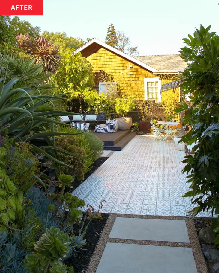 white house with black and white tiled large deck with wood accents in yard