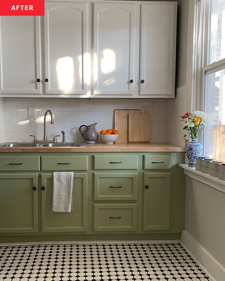 A kitchen with green and white cabinet and black and white tile floors.