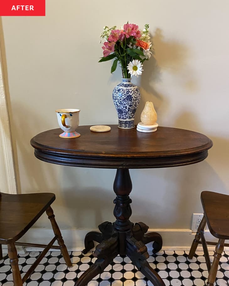A kitchen with a decorated tea table with two chairs.