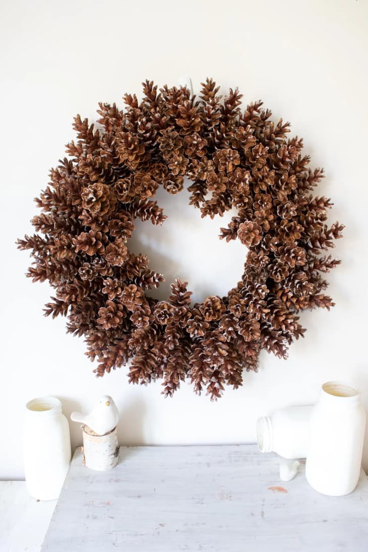 Round pinecone wreath on a white wall