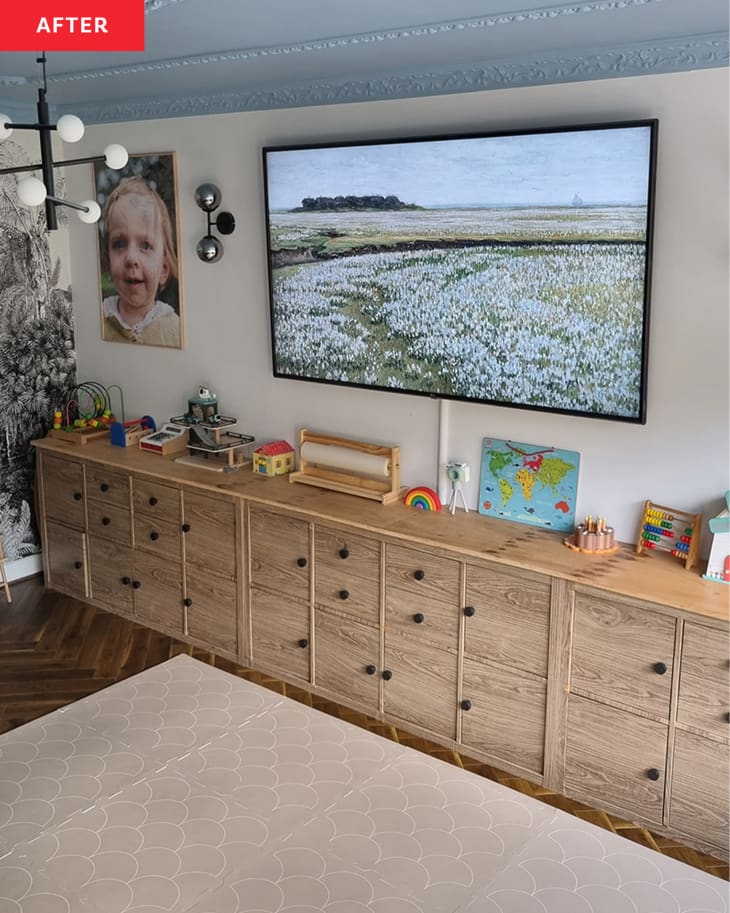 Toy storage cabinets below a large tv in a white living room.