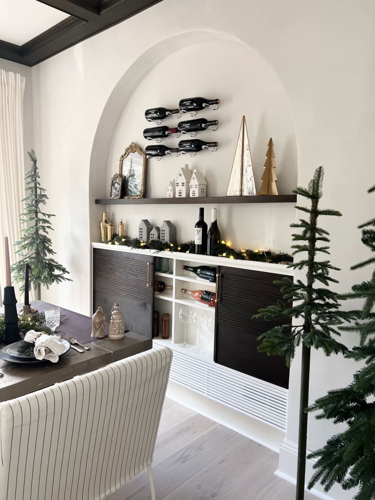Arched wall inset with cabinet doors hiding horizontal wine bottle storage
