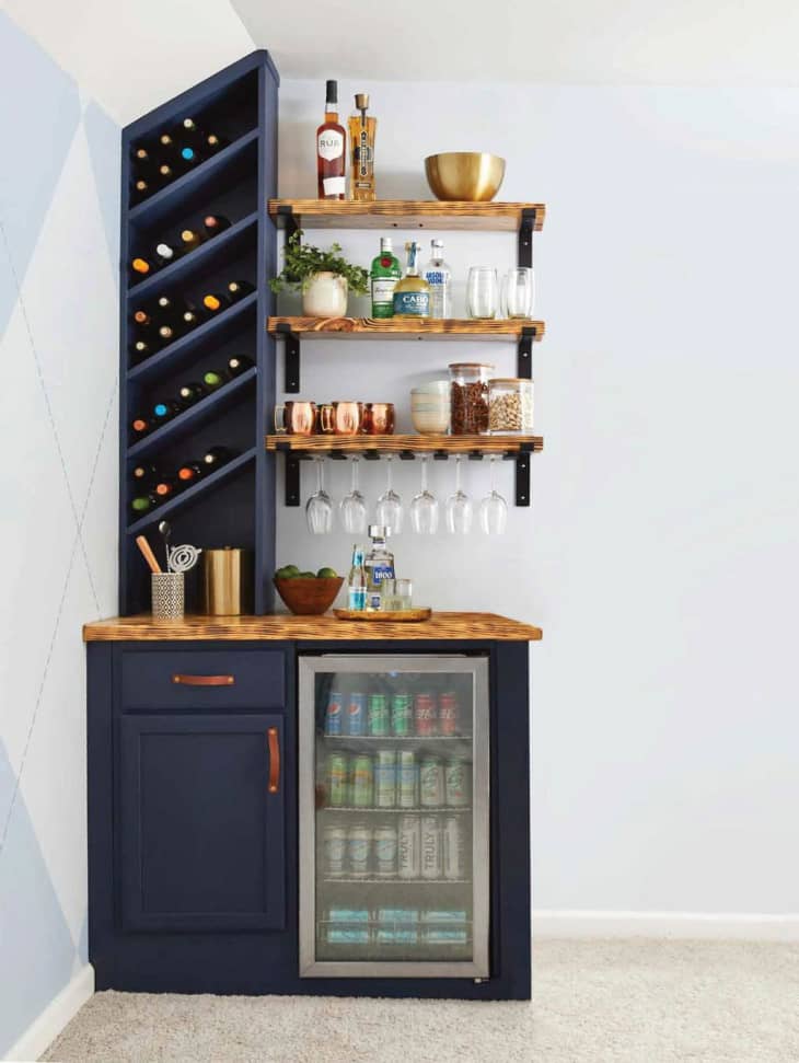 Mini-bar built into corner of a room, with angled shelves to store wine bottles horizontally.
