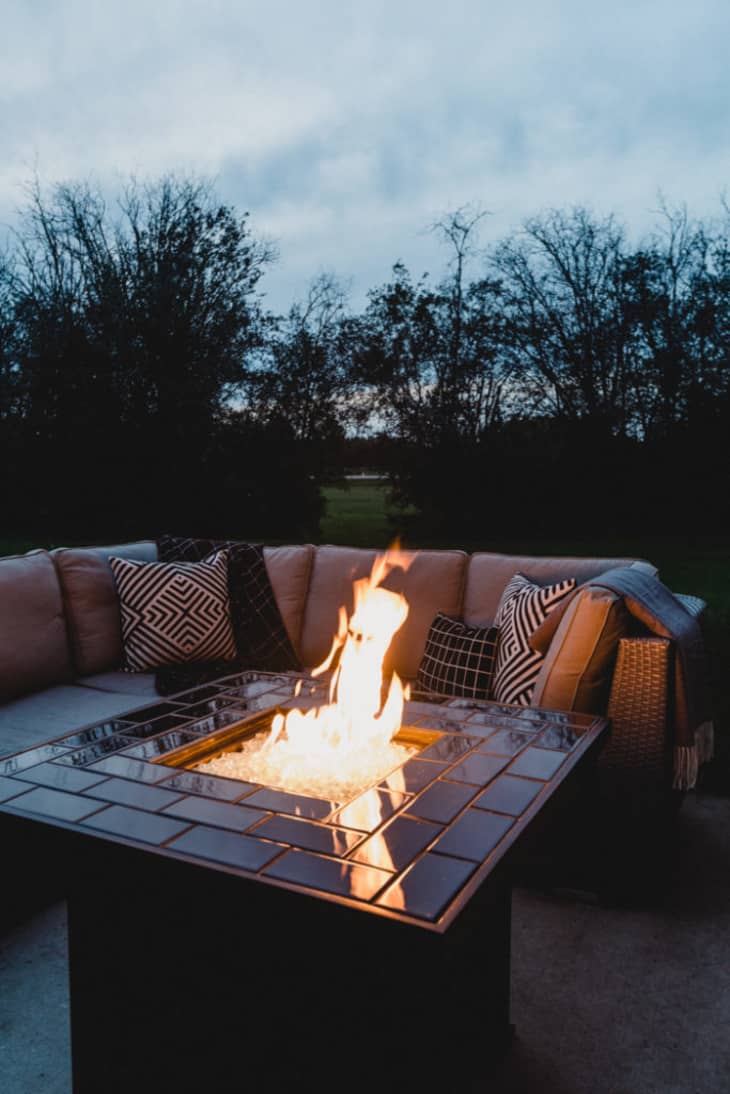 Raised fire pit with a black subway tiled border around the fire