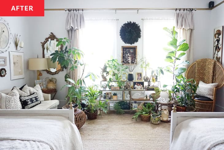Two beds overlook plants, white love seat next to glass shelves.