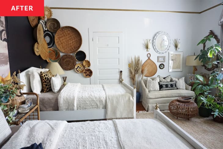 Bedroom with two beds and a white loveseat with woven baskets hanging from the ceiling.