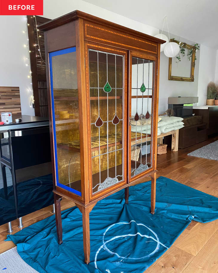 A brown wooden cabinet with glass doors