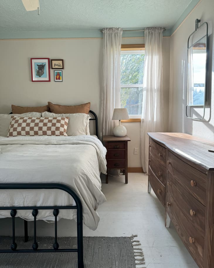 Wooden dresser in blue and cream bedroom.