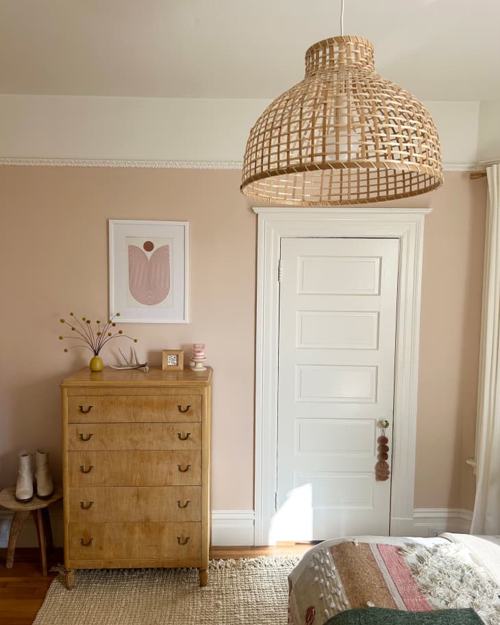 Wicker woven pendant in pink painted bedroom.