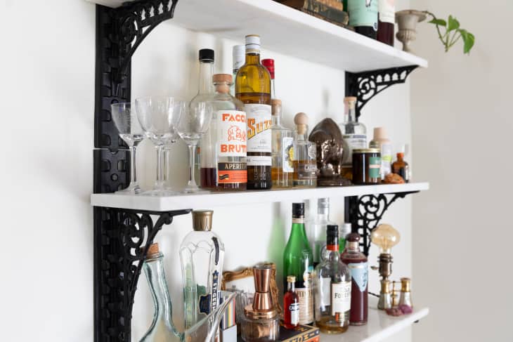 Wall-mount bar shelves made using vintage metal brackets with white quartz shelves resting on top