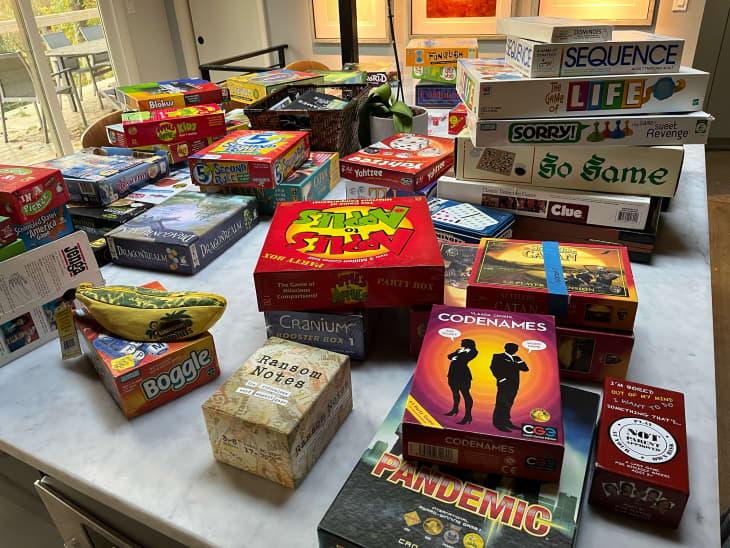 Boardgames laid out on dining room table during organizing.
