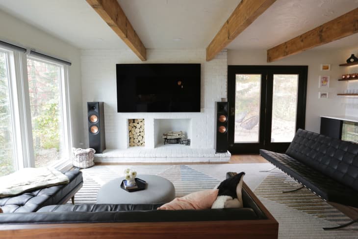 White living room with wood beams, wood floors, and black accents after renovation