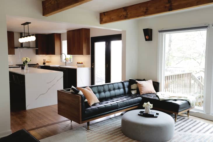 White living room with wood beams, wood floors, and black accents after renovation