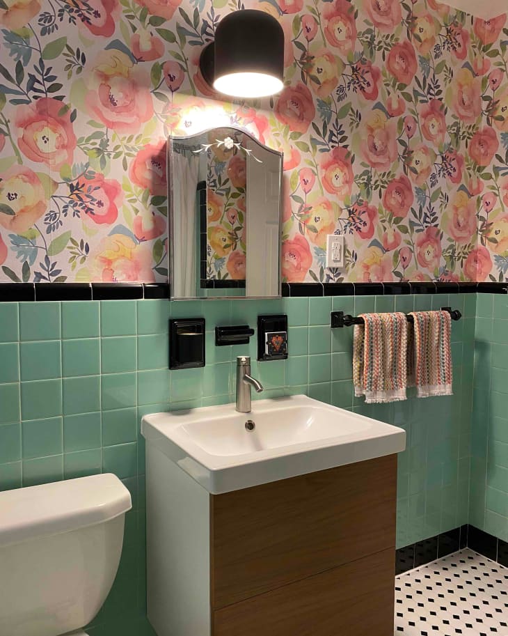 Floral wallpaper in bathroom with vintage green tiles.